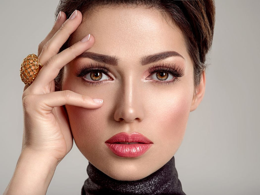 Close-up of woman's face showing full, defined eyelash extensions and soft glam eye makeup