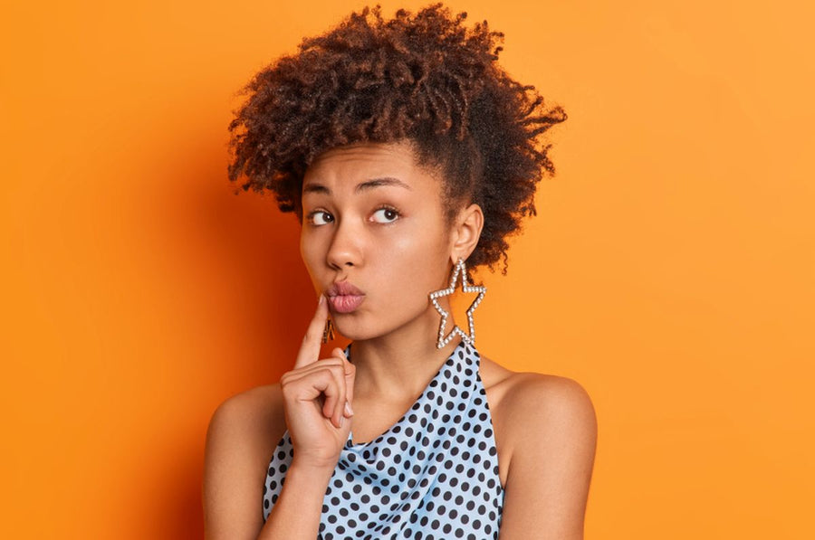 A concerned young beautiful Afro-American woman touching her lips